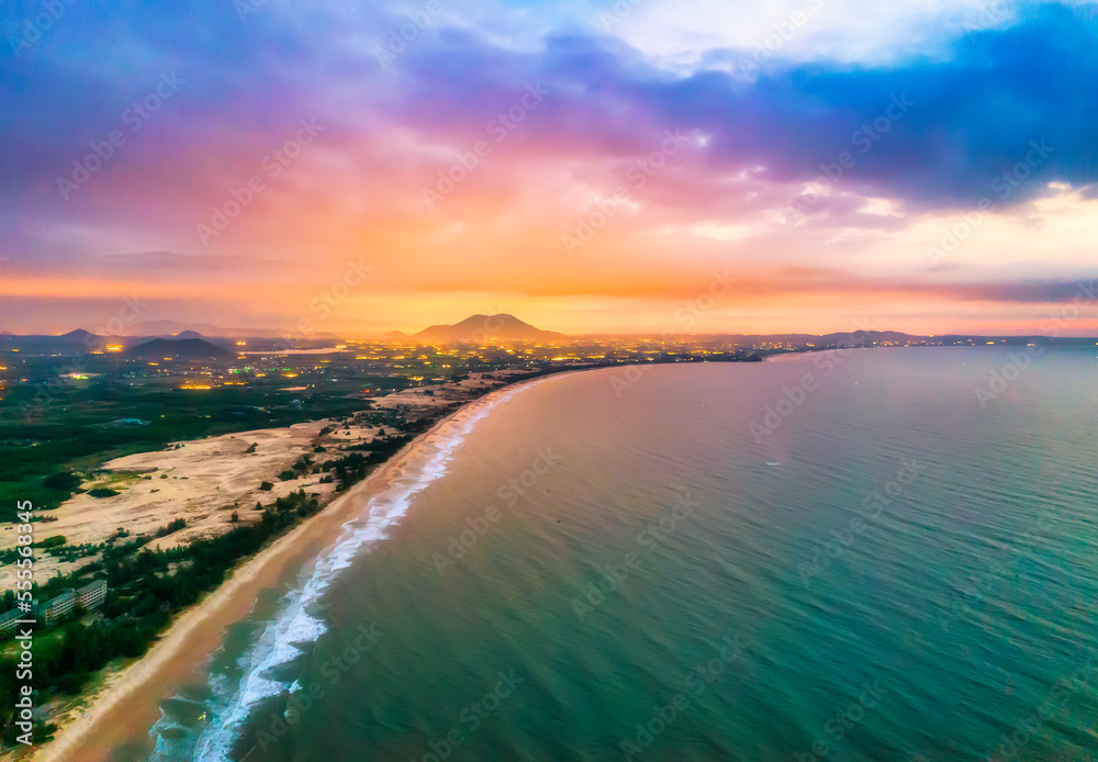 Aerial view of the central coast of Vietnam at dawn with the coast, blue sea waves, sunrise is a place for weekend relaxation and fishing of local fishermen