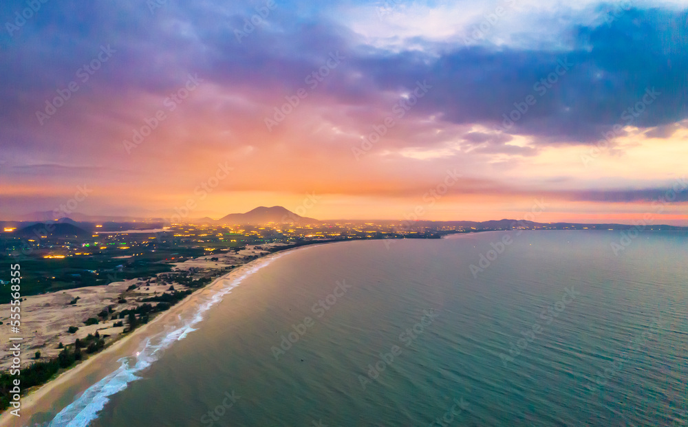 Aerial view of the central coast of Vietnam at dawn with the coast, blue sea waves, sunrise is a place for weekend relaxation and fishing of local fishermen