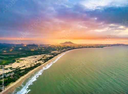Fototapeta Naklejka Na Ścianę i Meble -  Aerial view of the central coast of Vietnam at dawn with the coast, blue sea waves, sunrise is a place for weekend relaxation and fishing of local fishermen