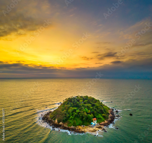 Aerial view of sea landscape with deserted island in a turquoise water and sunrise sky background