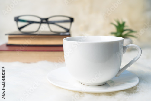 Coffee cup with book stacked on table