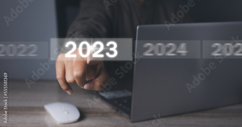 Welcome year 2023. Businessman hand pressing button New Year 2023.