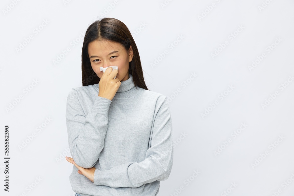 Sad Asian woman holding hand with handkerchief and coughing up flu and cold, stuffy nose viral disease asthma and allergies covid 19, white background Sad Asian woman holding hand with handkerchief and coughing up flu and cold, stuffy nose viral disease asthma and allergies covid 19, white background