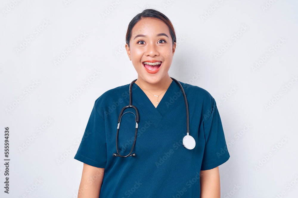 Excited Asian woman nurse wearing blue uniform with a stethoscope standing and looking camera isolated on white background. Healthcare medicine concept Excited Asian woman nurse wearing blue uniform with a stethoscope standing and looking camera isolated on white background. Healthcare medicine concept