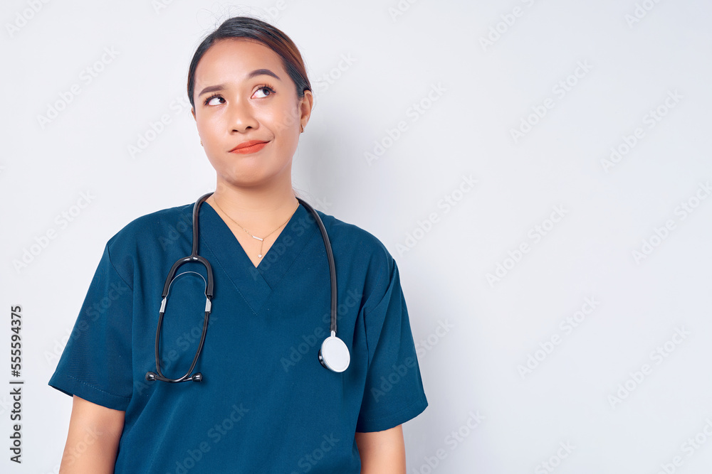Exhausted young Asian woman nurse wearing blue uniform with a stethoscope looking tired after her shift in the hospital, looking sad with fatigue on white background. Healthcare medicine concept Exhausted young Asian woman nurse wearing blue uniform with a stethoscope looking tired after her shift in the hospital, looking sad with fatigue on white background. Healthcare medicine concept