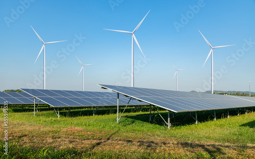 Solar panels and wind turbines open filed alternative EcoPower electricity solar energy and wind energy hybrid power plant systems station use renewable energy to generate power concept.