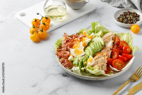 Cobb salad with bacon, avocado, tomato, grilled chicken, eggs isolated on  white background. American salad. Healthy food. photo