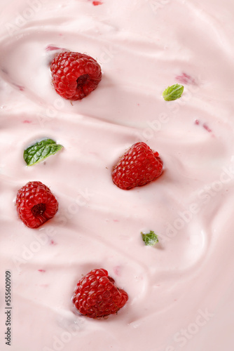 Texture, background of Pink Yogurt with raspberries. Curl of Yogurt. Pink nature yogurt, sour cream, ice cream.