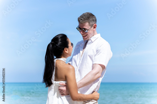 A couple of men and women of different nationalities go to the beach and walk happily on the beach together. on summer vacation