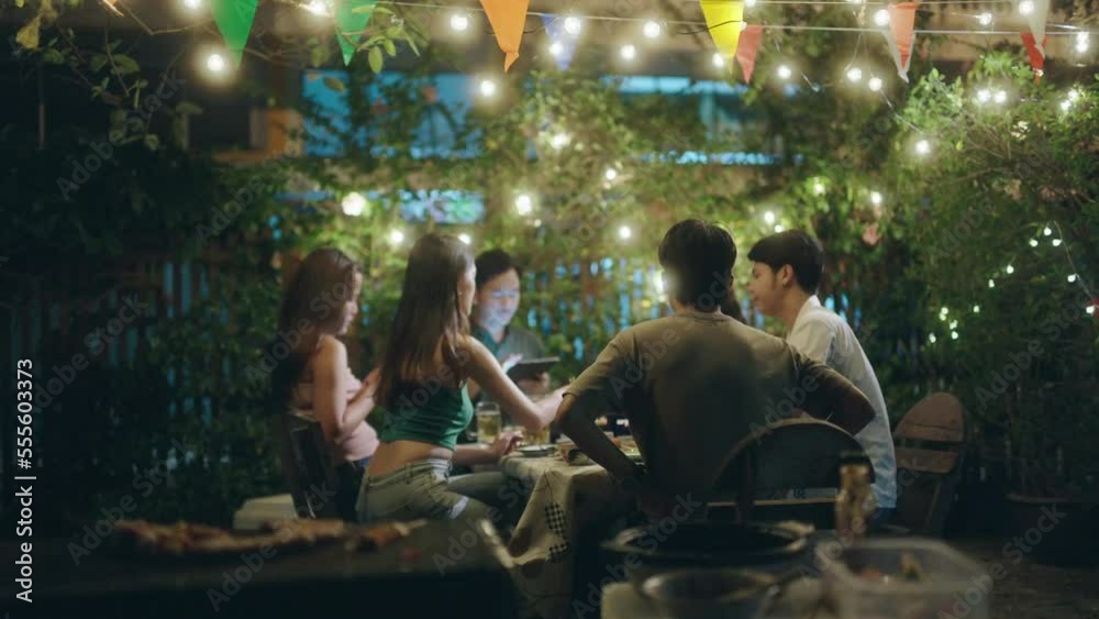 Asian people having a barbecue party and drinking beer.