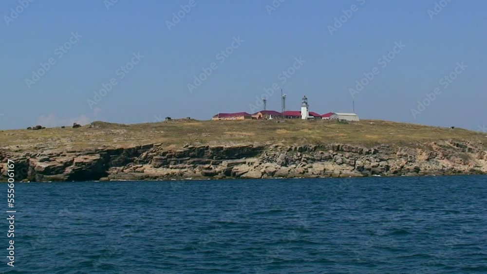 Snake Island in peacetime, sunny, the island is not far away, the lighthouse and buildings are visible. Black Sea, Ukraine. Snake Island in peacetime, sunny, the island is not far away, the lighthouse and buildings are visible. Black Sea, Ukraine.