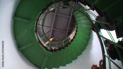 A group of tourists climb the stairs to the top of the Snake Island Lighthouse, viewed from below. Black Sea, Ukraine. photo