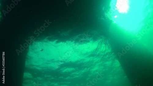 Sea pier, view from below. In the greenish rippling waters of the Black Sea, the Snake Island pier looks like a mysterious silhouette. Black Sea, Ukraine. photo