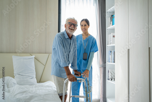 Asian women caregiver take care senior disabled man on wheelchair,Nurse support disabled senior man patient to walk at nursing home