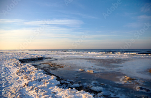 Fototapeta Naklejka Na Ścianę i Meble -  Winter landscape with icy sea coast and calm blue sky, selective focus