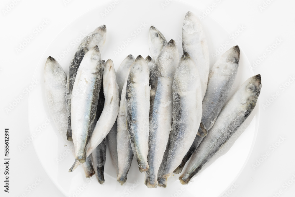 Frozen sea fish on a white plate, top view. Frozen sea fish on a white plate, top view.