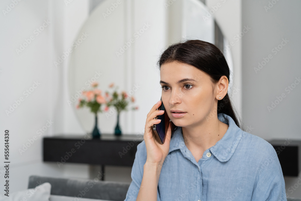 Brunette woman talking on mobile phone at home Brunette woman talking on mobile phone at home