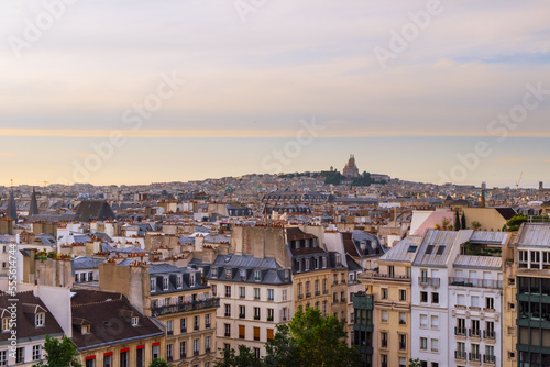 City day view of Parisian rooftops and Sacre-Coeur minor basilica from Centre Pompidou. Sacred Heart church in Montmartre hill. Popular landmark in Paris, France. Horizontal background and copy space.