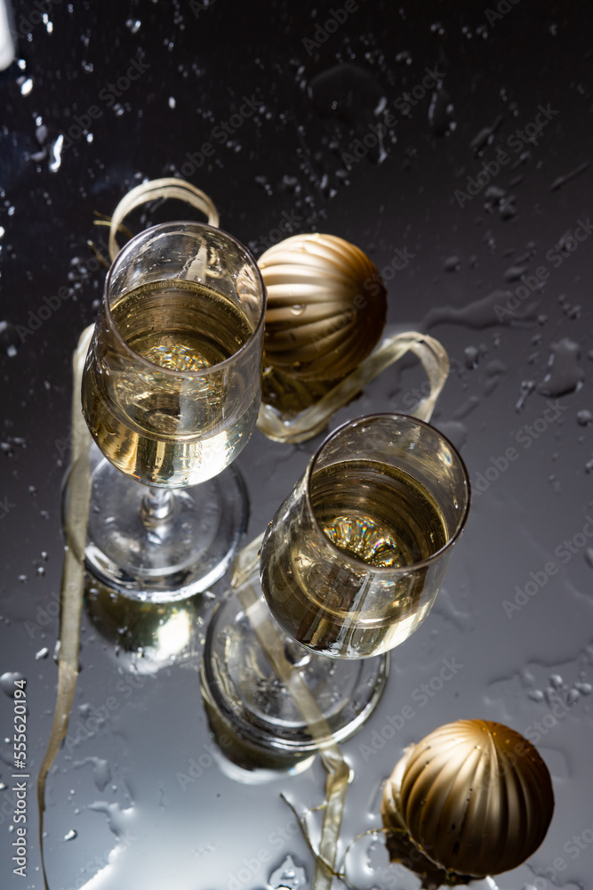 two champagne glasses reflecting in glass New Year background