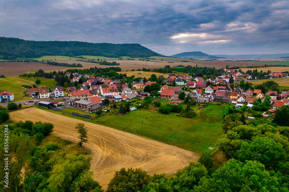 Fototapeta premium Aer ial view of a German village surrounded by meadows, farmland and forest in Germany.