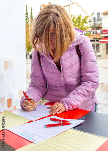 Photography woman filling out a form on the street