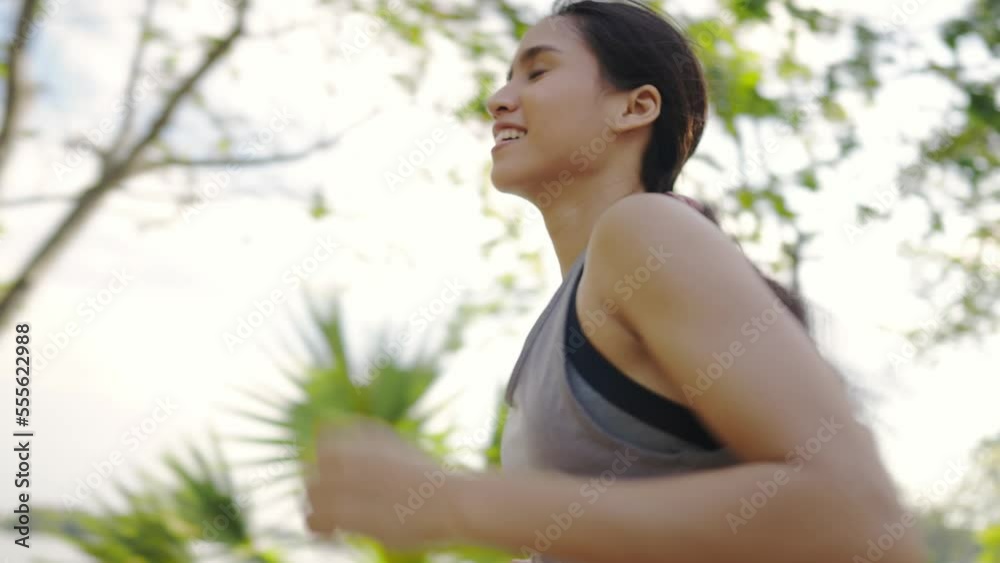 Asian woman, healthy, exercising outdoors. She is running. Asian woman, healthy, exercising outdoors. She is running.