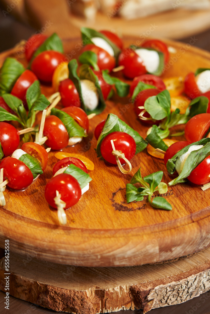 cherry tomatoes with mozzarella on skewers on a wooden tray. delicious diet snack. anipasti cherry tomatoes with mozzarella on skewers on a wooden tray. delicious diet snack. anipasti