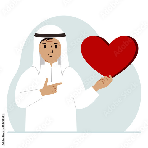 A man holds a big red heart in his hand. The concept of volunteering, romantic relationship or love.