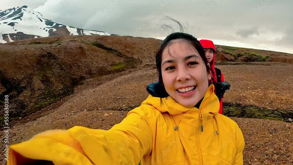 Young asian woman taking selfie video yourself and volcanic mountain on geothermal background in summer at Kerlingarfjoll Young asian woman taking selfie video yourself and volcanic mountain on geothermal background in summer at Kerlingarfjoll