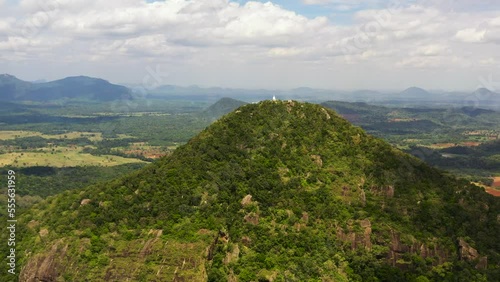 Buddhist monastery on top of a mountain on the background of a valley with tropical vegetation. Sri Lanka. photo