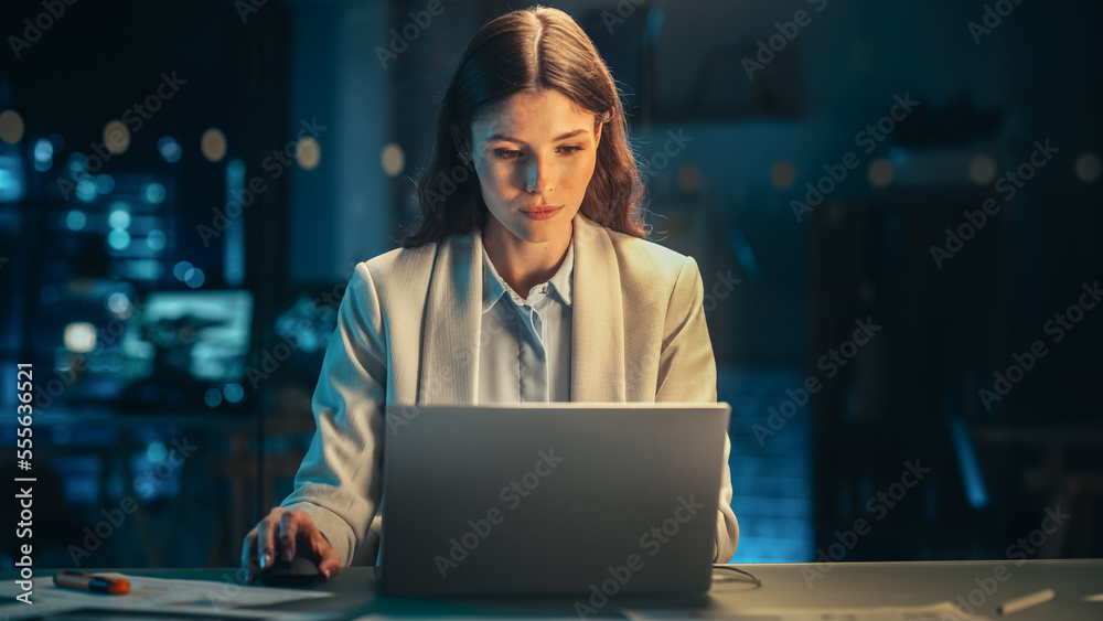 Beautiful Female Working on Laptop Computer in a Company Office at Night. Young Secretary Analyzing Reports. Marketing Assistant Developing a Marketing Strategy for a Client. Beautiful Female Working on Laptop Computer in a Company Office at Night. Young Secretary Analyzing Reports. Marketing Assistant Developing a Marketing Strategy for a Client.