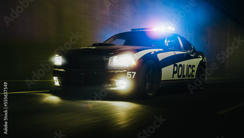 Night Shift Traffic Patrol Car In Pursuit Driving Fast with Sirens Blazing through the City Streets. Officers of the Law Chasing a Suspect. Cops in Squad Car Ready to Fight Crime. Cinematic Night Shot © Gorodenkoff