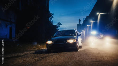 Traffic Patrol Car in Pursuit. Police Officers in Squad Car Chasing Suspect on Industrial Road, Sirens Blazing, High Speed. Cops on Emergency Response Call. Stylish Cinematic Action