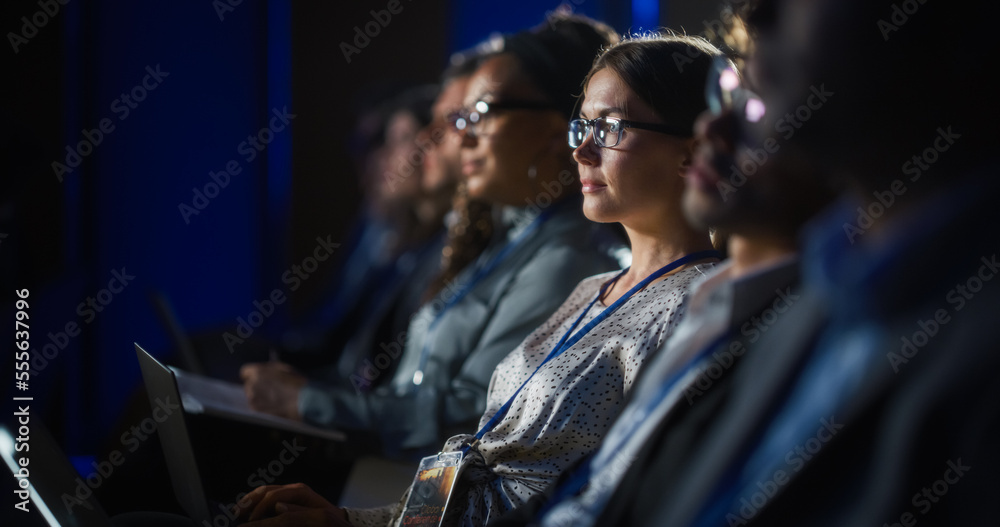 Young Psychologist Attending an International Cognitive Behavioral Therapy Seminar. Specialist Using Laptop Computer. Psychotherapy Professional Sitting in a Crowded Room on a Training Program.