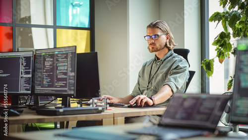 Male Data Scientist Coding on Desktop Computer in Creative Office Space. Caucasian Man Scraping Digital Information From Opened Sources in Internet For Artificial Inteligence Software Development.