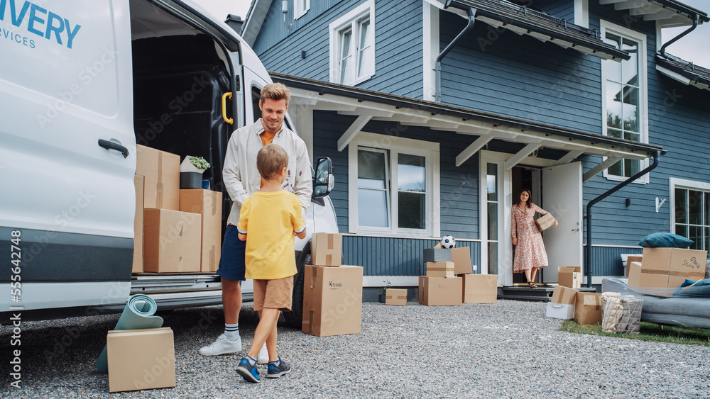 Handsome Man Unloading a Cargo Van Full of Cardboard Moving Boxes. Young Happy Family with a Son Moving to Their Dream Home in the Suburbs. Delivery Transportation Car Sharing Service. Handsome Man Unloading a Cargo Van Full of Cardboard Moving Boxes. Young Happy Family with a Son Moving to Their Dream Home in the Suburbs. Delivery Transportation Car Sharing Service.