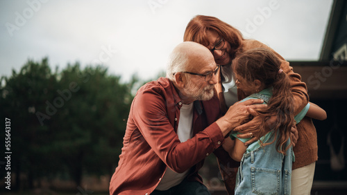 Fotografia Grandfather and Grandmother are Happy to Meet Their Granddaughter in Front of their Suburbs House