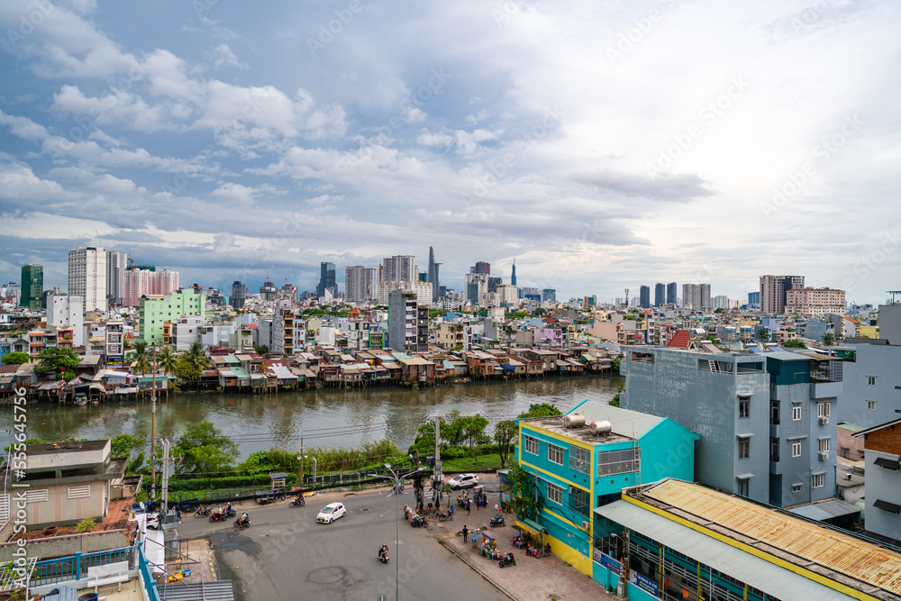 HO CHI MINH, VIETNAM - December 3, 2022: Slum wooden house on the Saigon river bank, in front of modern buildings in ho chi minh city. View to district 1, see Bitexco tower, Landmark 81. HO CHI MINH, VIETNAM - December 3, 2022: Slum wooden house on the Saigon river bank, in front of modern buildings in ho chi minh city. View to district 1, see Bitexco tower, Landmark 81.