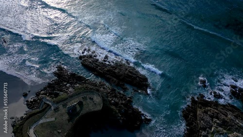 Sea Waves Splashing On Rocky Coastal Park Near Caion Beach In A Coruna, Spain. aerial topdown photo