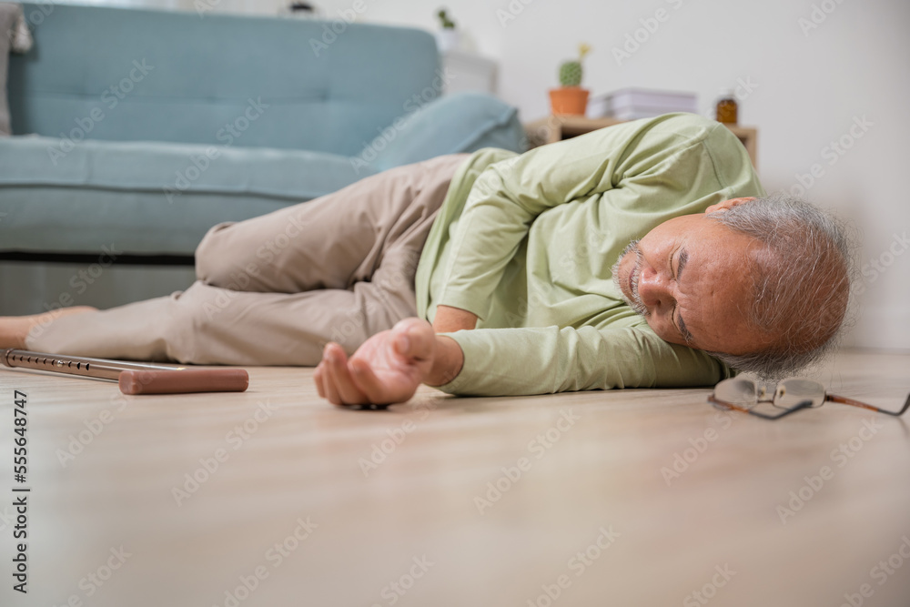 Older senior man headache lying on the floor after falling down he pain and hurt from osteoporosis, Elderly man falling on the floor alone with walking stick at home, Health care and medicine Older senior man headache lying on the floor after falling down he pain and hurt from osteoporosis, Elderly man falling on the floor alone with walking stick at home, Health care and medicine