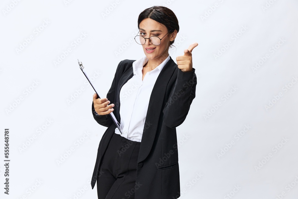 Business woman with a folder of documents in her hands in a black business suit and glasses shows signals gestures and emotions on a white background, work freelancer online training Business woman with a folder of documents in her hands in a black business suit and glasses shows signals gestures and emotions on a white background, work freelancer online training