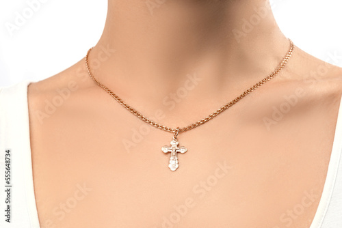 isolated on white background jewelry silver cross on a golden chain around the neck of a model girl. Front and side view of jewelry on girl