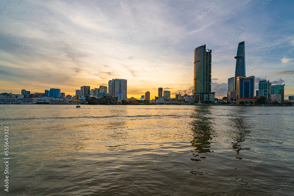 Ho Chi Minh City skyline and the Saigon River at sunset. Amazing colorful view of skyscraper and other modern buildings. Travel concept