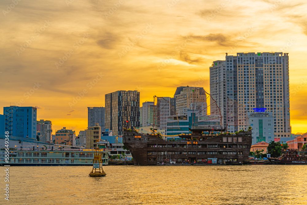 Obraz premium Ho Chi Minh City skyline and the Saigon River at sunset. Amazing colorful view of skyscraper and other modern buildings. Travel concept