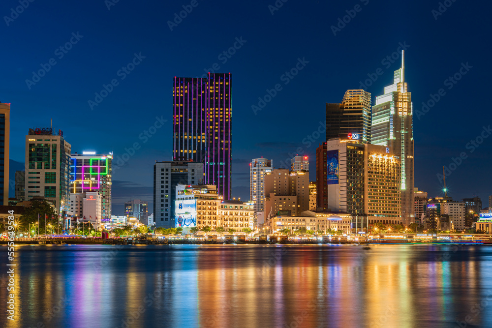 Ho Chi Minh City skyline and the Saigon River at night. Amazing colorful view of skyscraper and other modern buildings. Travel concept