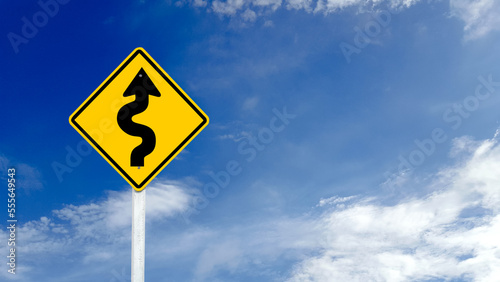 Yellow warn sign with switchback arrow starting from the right on blue sky background