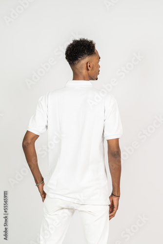 Back side of an african man with polo shirt doing a pose with white background
