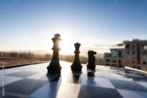 Chess king, queen and knight on city background