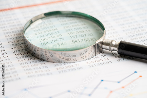Magnifying glass on charts graphs paper. Financial development  Banking Account  Statistics  Investment Analytic research data economy  Stock exchange trading  Business office concept.