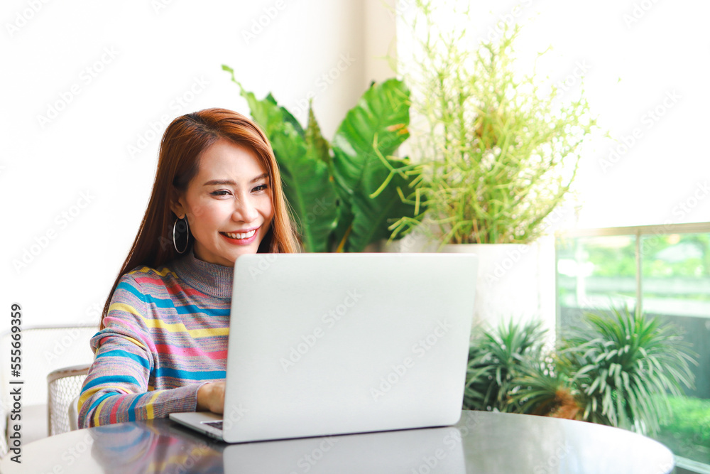 Asian woman sitting and working at home smiling happy. Online business concept. entrepreneur. freelance. Asian woman sitting and working at home smiling happy. Online business concept. entrepreneur. freelance.